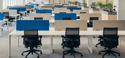 Modern open-plan office space featuring clean workstations, ergonomic chairs, and sanitized carpets provided by professional office cleaning services in Colorado Springs, CO.
